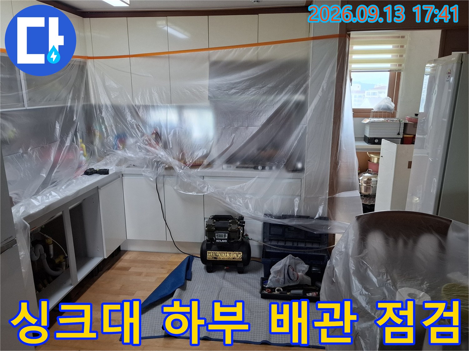 비닐로 꼼꼼하게-보양된 싱크대 하부와-누수 검사용 장비의 모습입니다.