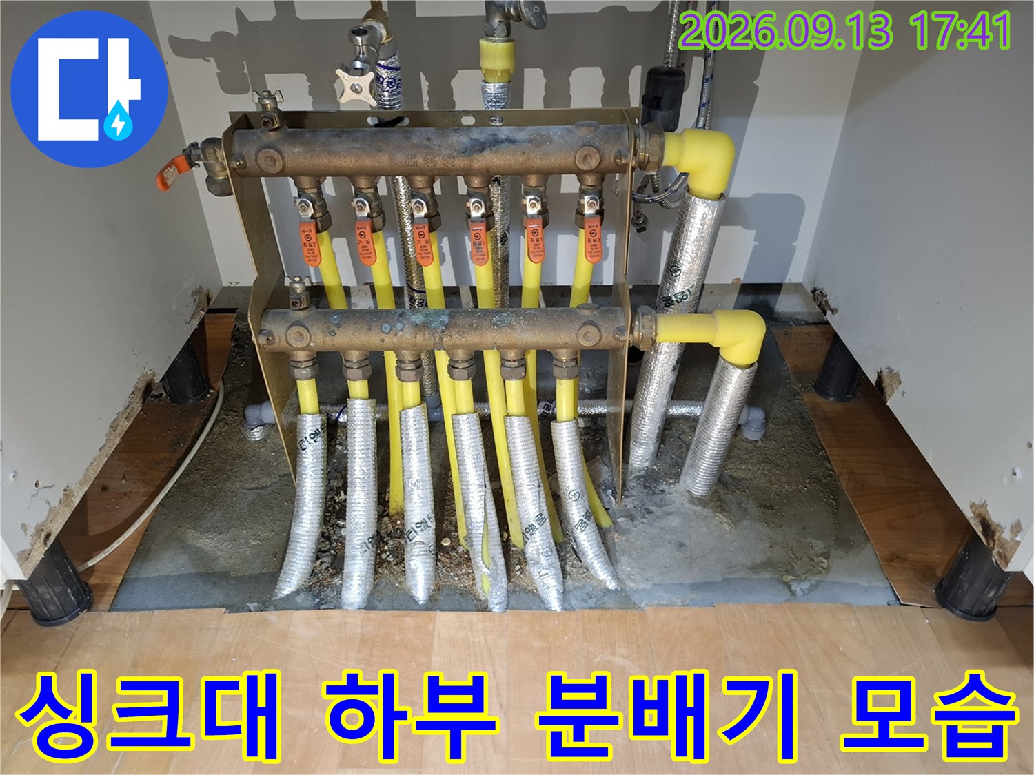 싱크대 밑 공간에 노출된 보일러 분배기와 배관 부속들입니다.