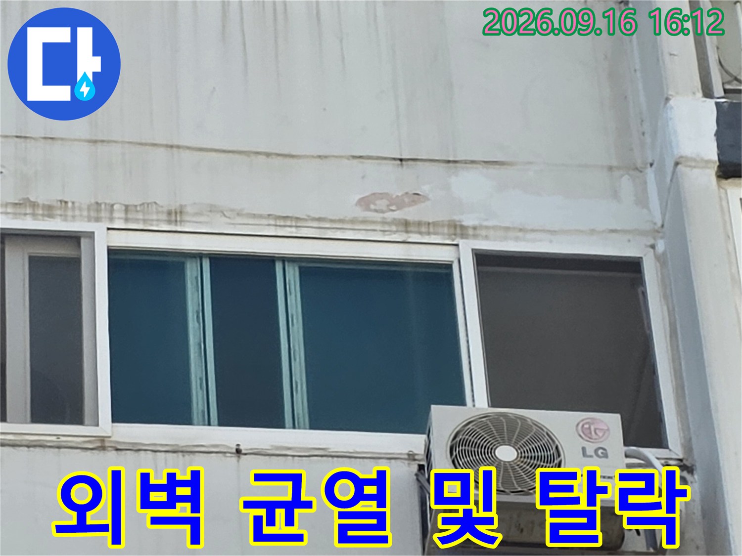 외벽 마감재가 떨어져 나가고 균열이 생긴 창틀 상단 부위의 근접 사진입니다.