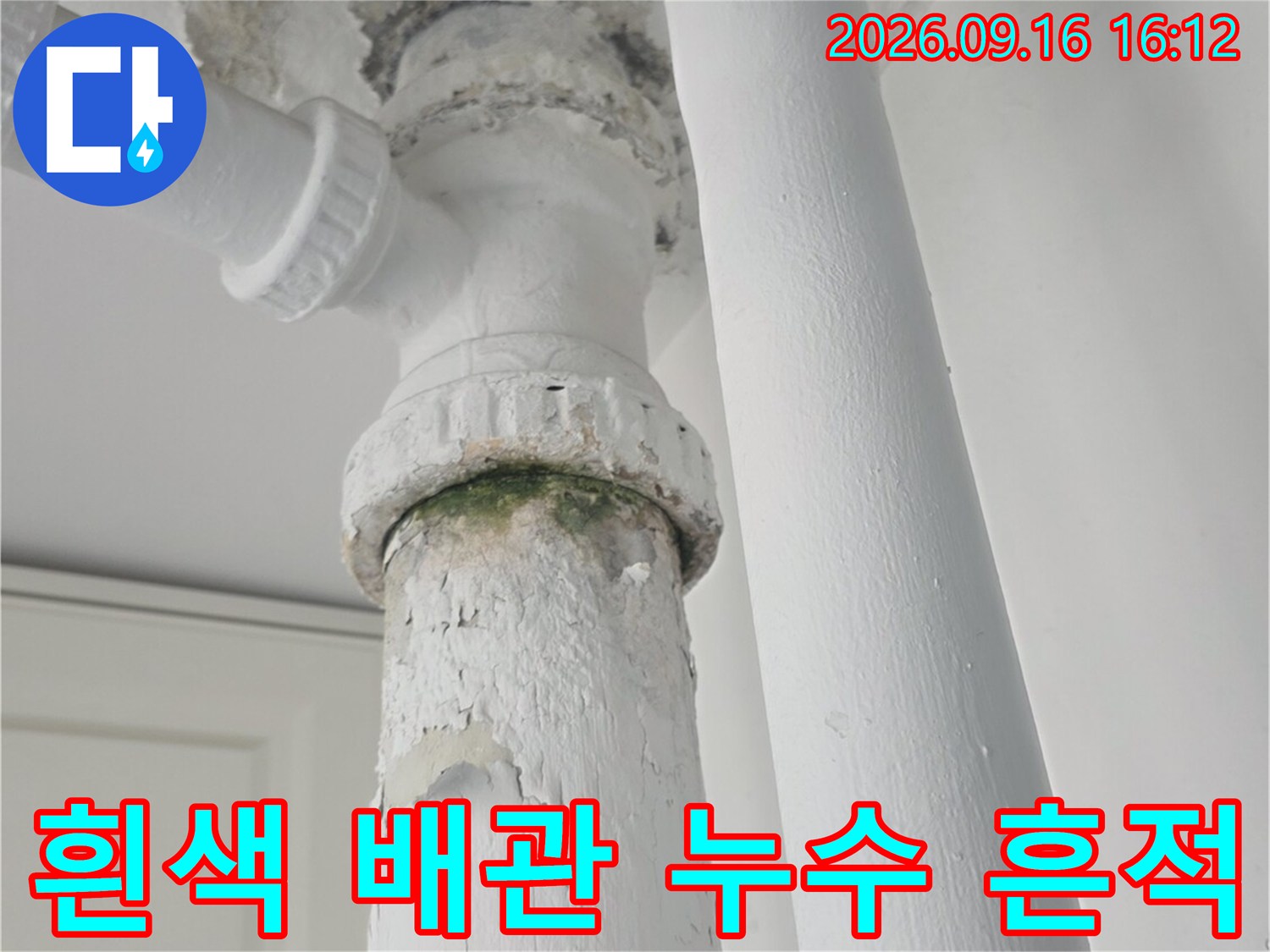 천장 흰색 배관-연결 부위의 습기 맺힘과 오염을 보여줍니다.