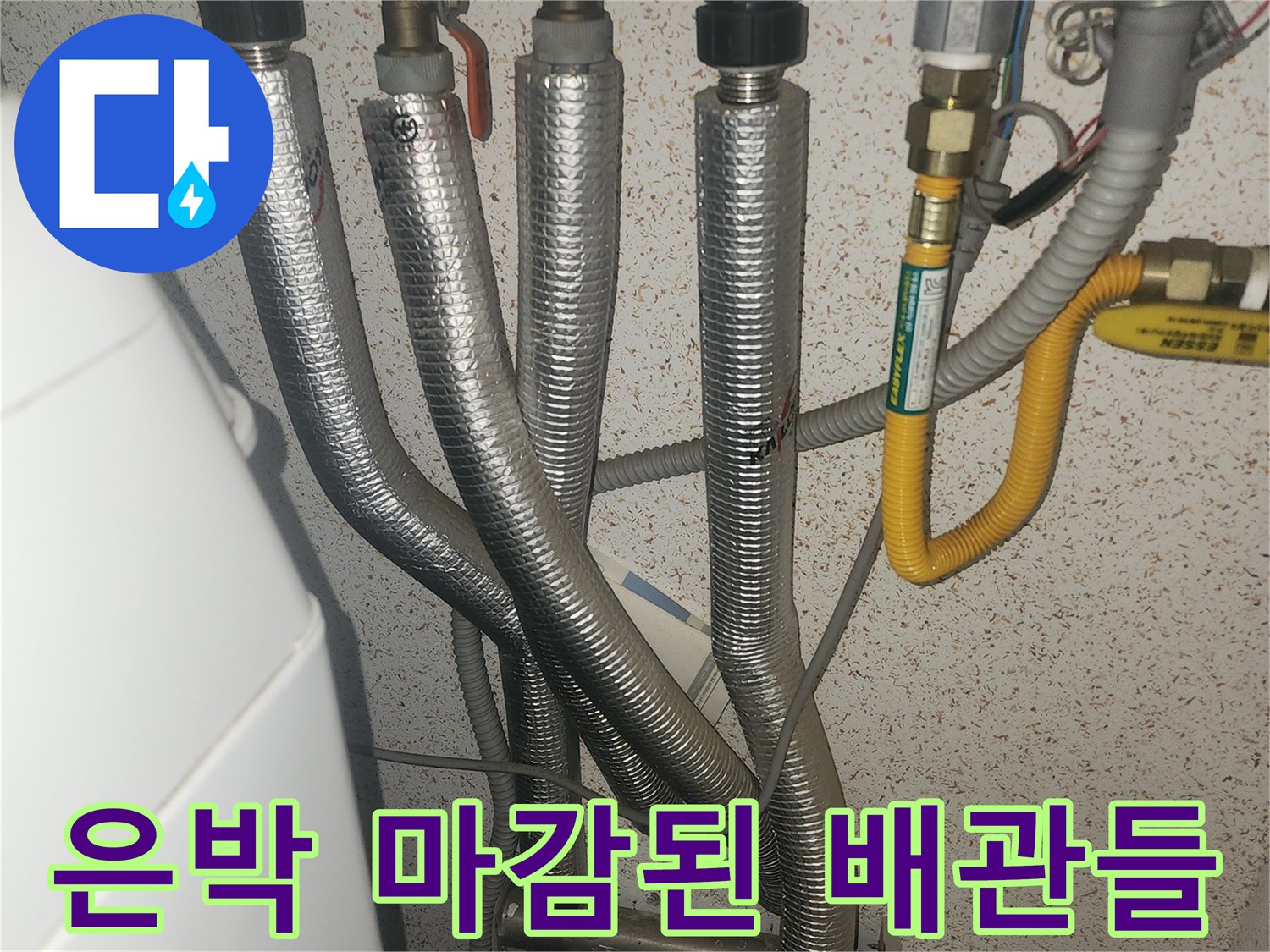 보일러 하단에 연결된 은박 보온재로 감싸진 배관 모습