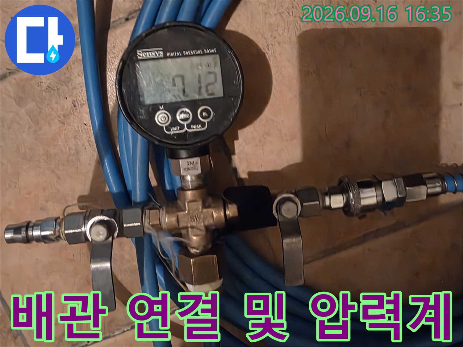 파란색 호스와 금속 밸브가 연결된 압력 측정 시스템