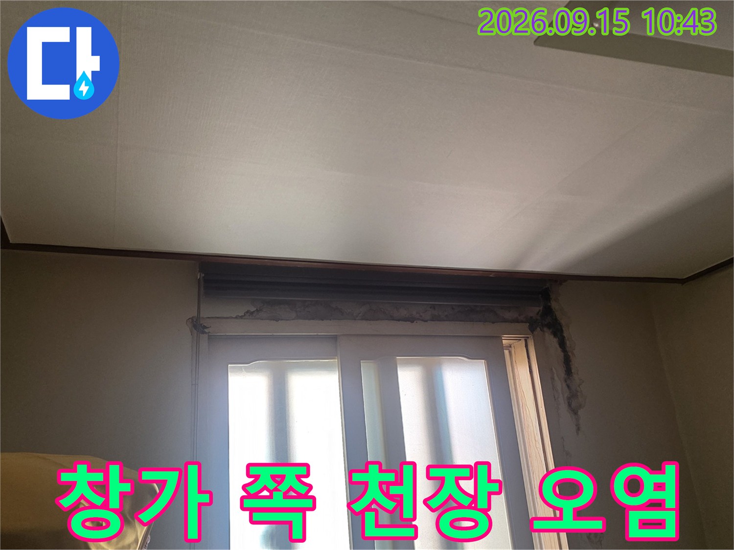창문 상단 천장 마감재에 발생한 어두운 누수 얼룩