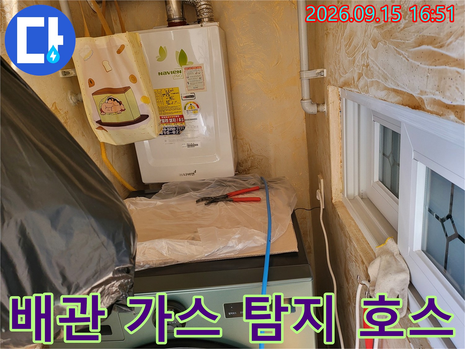 보일러 하단 배관에 연결된 노란색 가스 주입용 호스