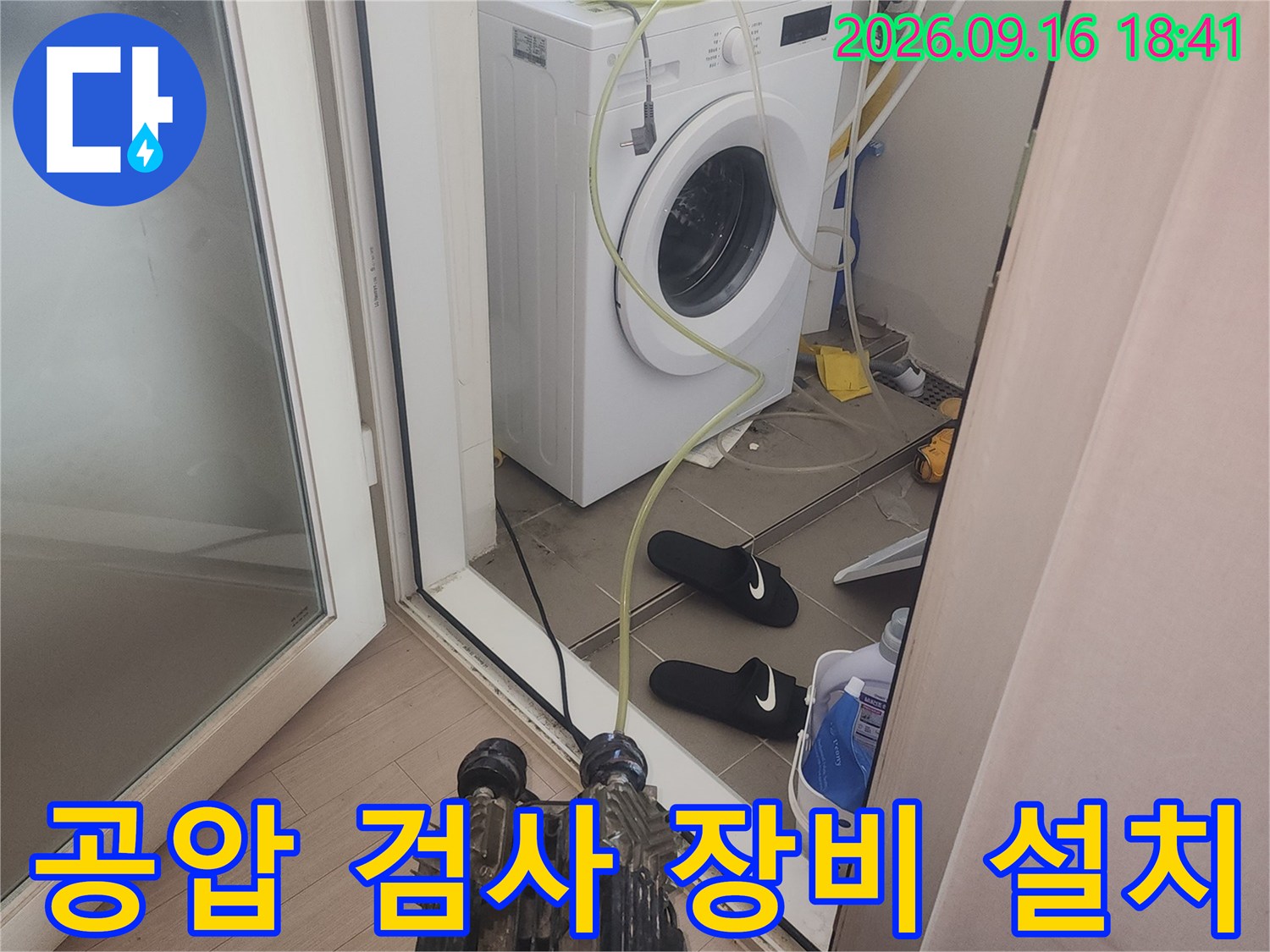 세탁기 근처 수도 배관에 연결된 공압 테스트용 호스 및 게이지