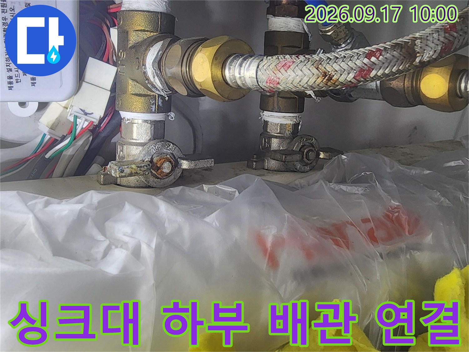 싱크대 아래쪽의 수전 연결 부품과 호스들의 모습