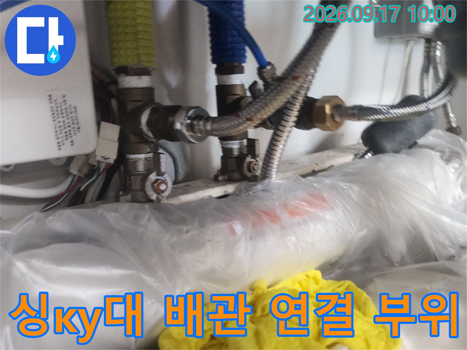 싱크대 하단의 금속 배관과 유연한 호스들의 연결 상태입니다.