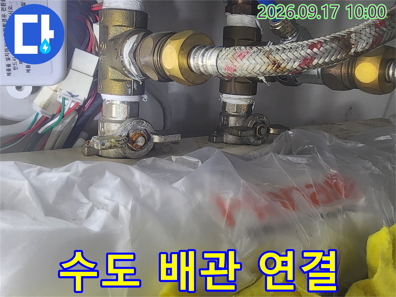 싱크대 하단의 수도 호스와 금속 연결 소켓 모습