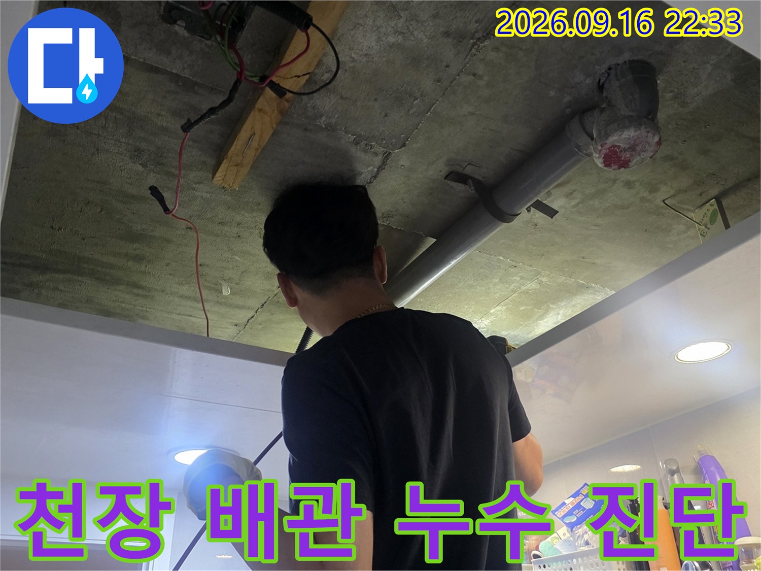 천장 내부의 노출된 배관과 전기 설비를 점검하는 작업 현장